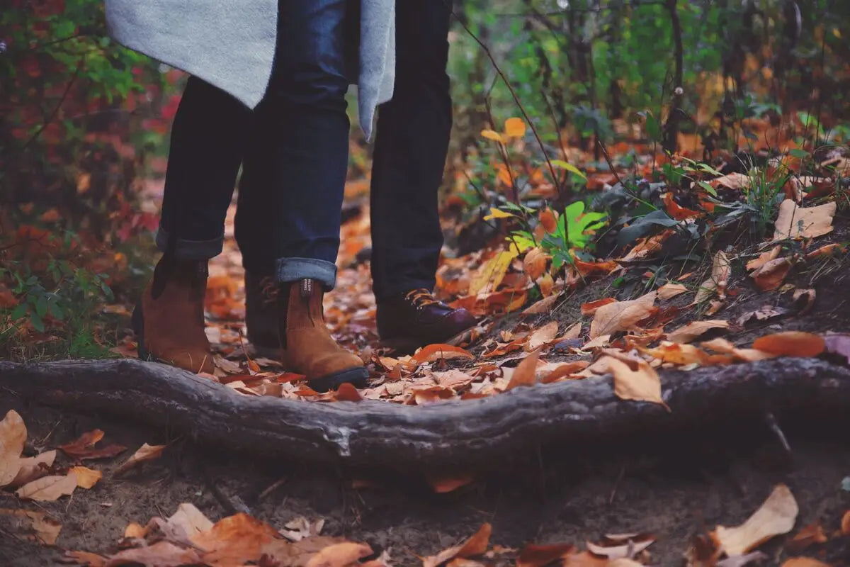 A couple hiking in the forest wearing leather and rubber-soled boots