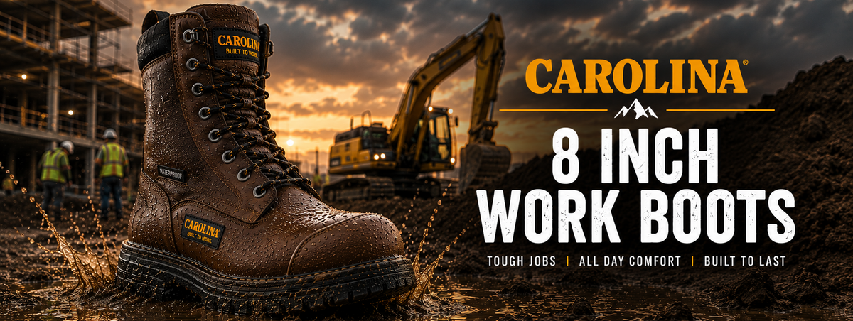 A brown Carolina 8-inch work boot shown prominently in the foreground on a muddy construction site at sunset, with excavators and workers blurred in the background.