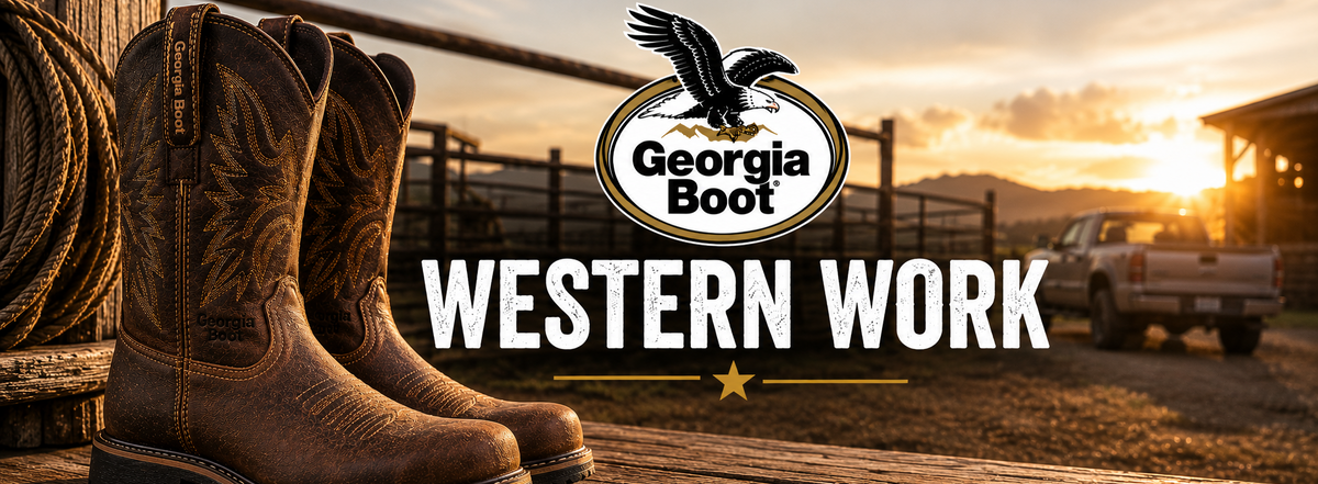 Pair of brown western boots displayed on a wooden fence at sunset, with a pickup truck and mountains in the background.