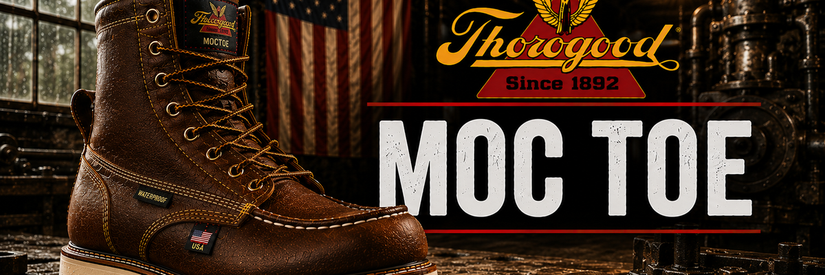 A brown leather Thoroughbred MOC Toe work boot with a thick off-white sole, shown in a dark industrial workshop setting with an American flag in the background.