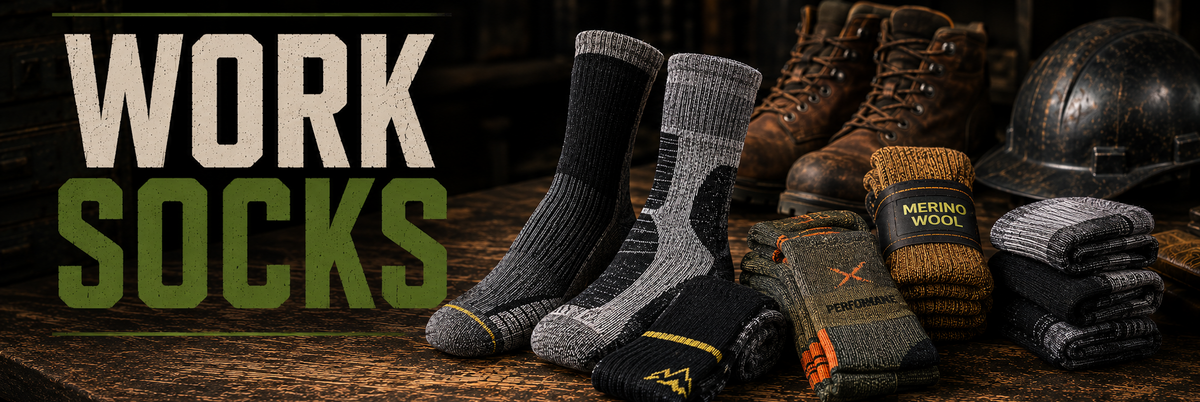 Work socks displayed on a rustic wooden surface with boots, a helmet, and folded socks in the background. Large text on the left reads 'WORK SOCKS'.