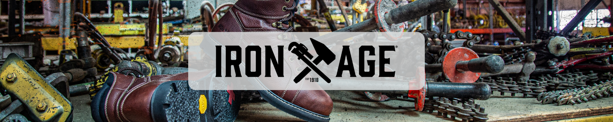 Iron Age logo over brown leather work boots in an industrial workshop