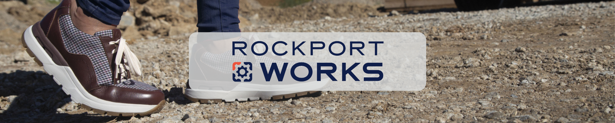 Rockport Works logo over brown lace-up work shoes on gravel